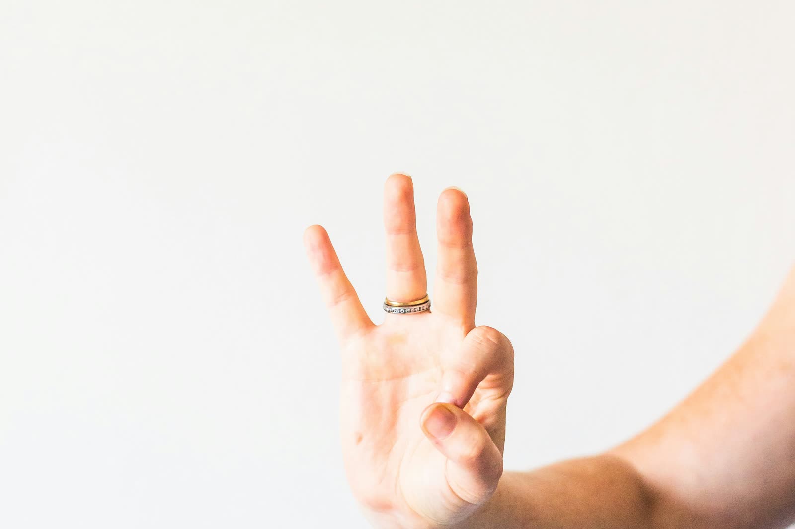 A hand holding up three fingers